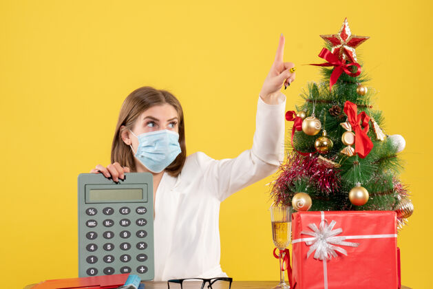 大流行正面图女医生戴着无菌口罩手持计算器圣诞节持有病毒