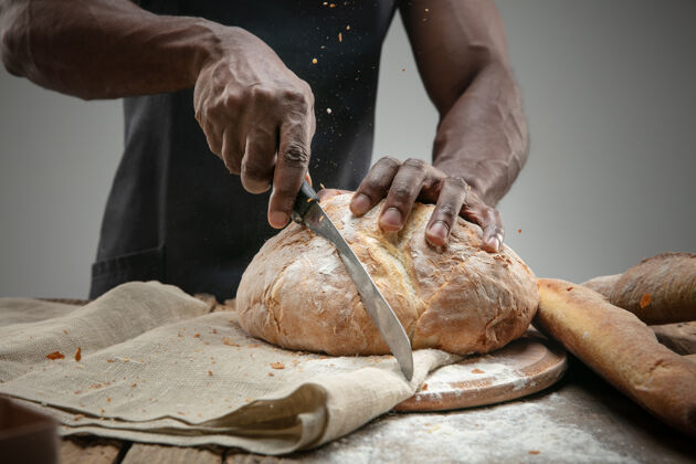复制空间非洲裔美国人用菜刀切新鲜面包的特写镜头切割食物年轻