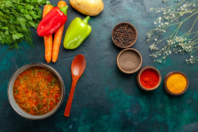 顶部俯瞰美味的蔬菜汤与不同调味料的深绿色表面食物餐蔬菜配料汤产品原料不同的胡椒