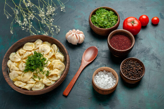 盘子俯瞰美味的饺子汤 不同的调味料放在绿桌上 汤菜肉面团晚餐蔬菜碗