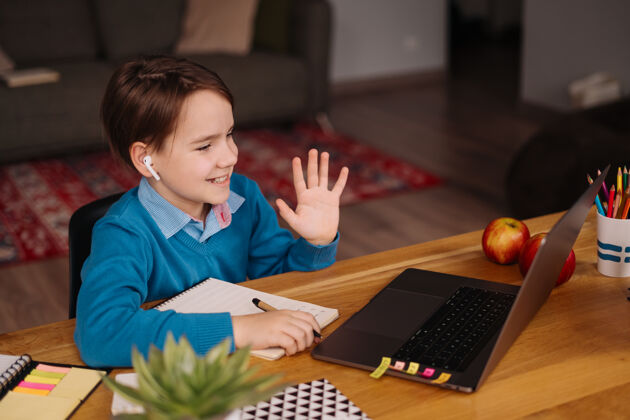 社会距离一个未成年男孩用笔记本电脑上网上课 向老师问好在线教育洋葱笔记本电脑