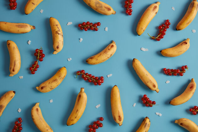 五颜六色红醋栗和黄香蕉 用于蛋糕 面包馅 做果酱 果汁 自制或冰沙收集异国水果和成熟浆果平面模式美味的夏季水果椰子背景季节