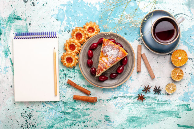 颜色俯瞰美味的蛋糕片配上一杯茶放在蓝色的桌子上蛋糕烤派饼干甜顶部视图桌子