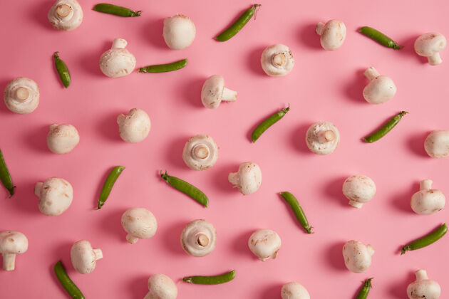 生的粉红色背景上的白色香菇和青豆准备美味汤或比萨饼的新鲜蔬菜食物摄影生熟作物美味蘑菇选择性聚焦作物素食品种