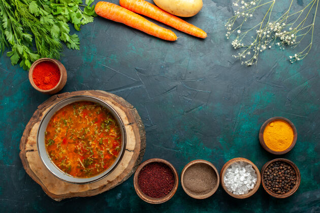 五颜六色顶视图蔬菜汤与调味品上深绿色的背景材料汤餐食品蔬菜蔬菜木勺背景