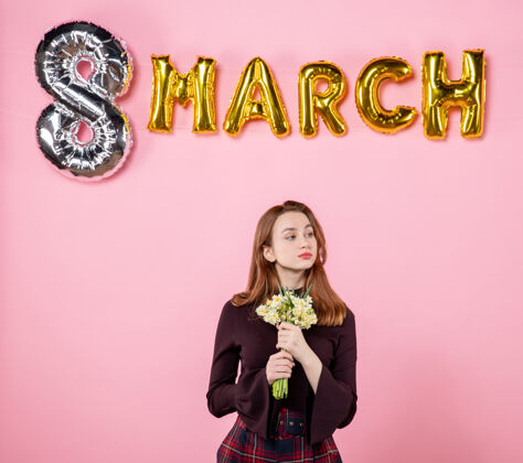 8正面图：手拿鲜花的年轻女性 粉色背景上的三月装饰派对妇女节三月结婚激情感官平等8人年轻的女性
