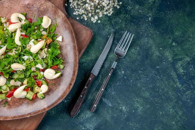 餐厅顶视图美味的蔬菜沙拉 盘子里有餐具 背景为深蓝色 烹饪健康 颜色合适 晚餐 厨房 饮食 午餐 餐厅餐具里面盘子