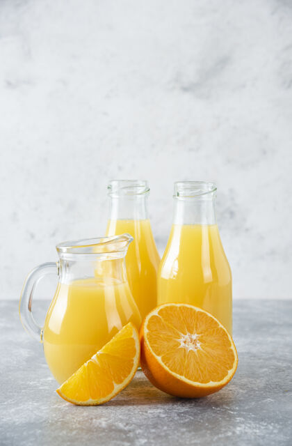 异国情调石桌上放着一杯果汁和新鲜的橙子果汁多汁新鲜