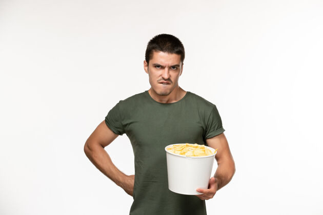 电影正面图身穿绿色t恤的年轻男性 白色墙上有土豆cips电影人男性孤独电影电影院年轻男性容器马克杯
