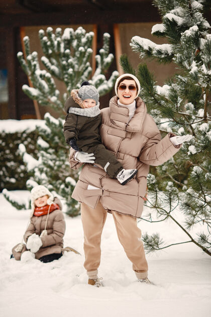 家庭一家人穿着冬装在雪林里度假温暖孩子季节