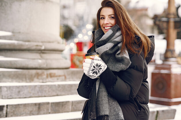 女性一个穿着黑色夹克 喝着外卖咖啡的女人的特写肖像森林外套雪
