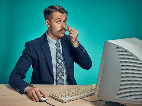 工人坐在电脑前办公桌旁摸胡子的商人董事屏幕帅哥