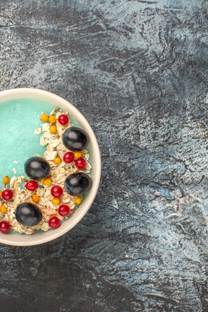 比萨饼顶视图：蓝色碗里的开胃葡萄和红醋栗碗蓝色帽子