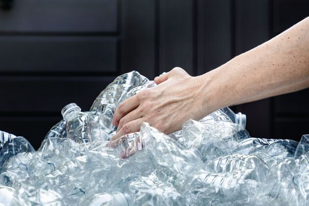 帮助女人们用手抓着塑料瓶来收集和扔掉它们垃圾废物脸