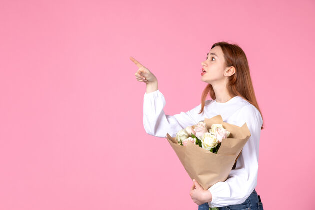 年轻的女性正面图：年轻女性 带花朵 作为女性节礼物 粉色背景 水平女性三月 爱情女性 性感约会 平等玫瑰人花束玫瑰