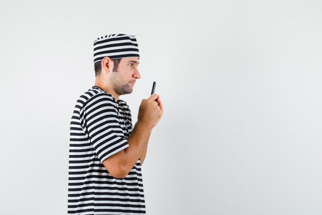 脸一个穿着t恤 戴着帽子 拿着手机 神情沉思的年轻男人沉思模特思考