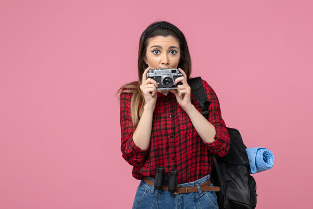 黑发前视图穿着红色衬衫的年轻女性 相机放在粉色背景的模特照片上相机微笑成人