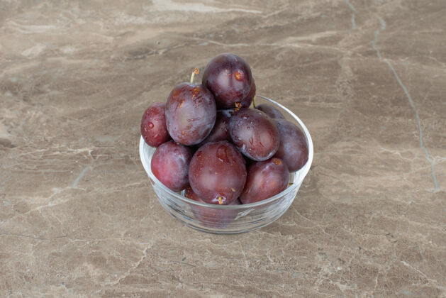 成熟一碗新鲜的李子放在大理石上水果健康天然