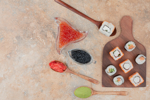 鱼子酱美味的寿司 鱼子酱 姜和瓦萨比放在木盘上食物好吃寿司
