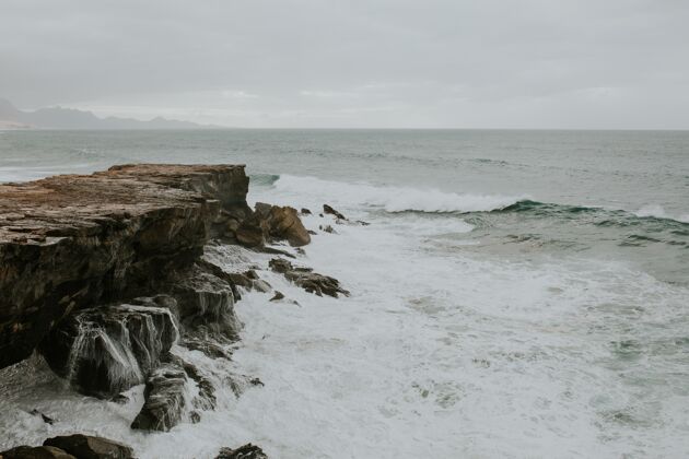 石头美丽的景色泡沫波到达岩石海岸水清晰自然