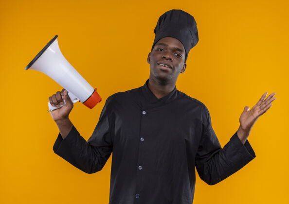 制服身穿厨师制服的年轻困惑的美国黑人厨师手持扩音器 在橘子上举手 留有复印空间年轻橙色大声