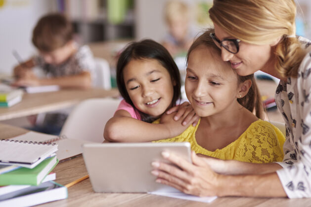 微笑老师用数字平板电脑帮助学生孩子帮助数字平板电脑