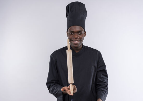 烹饪身着厨师制服 面带微笑的年轻美国黑人厨师将擀面杖放在白色的手指上 留有复印空间空间滚动非裔美国人
