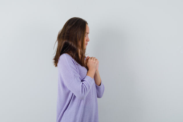 奢华年轻女子穿着淡紫色上衣祈祷 看上去很平静女士化妆美丽