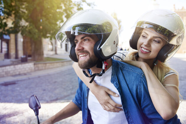 男人一对戴头盔的夫妇骑着摩托车女人债券阳光