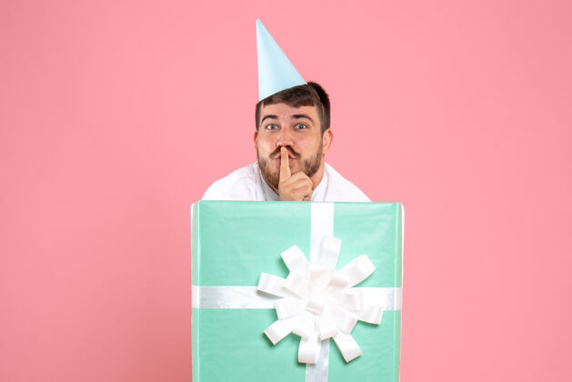 礼物正面图：年轻男性站在礼物盒内的粉色照片颜色情感圣诞睡衣派对情感帽子正面