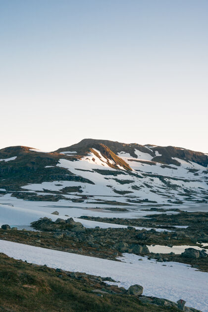 清晰山上的雪和石头的垂直镜头天空垂直霜冻