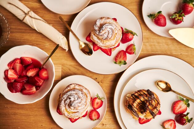 自制头顶拍摄美味的奶油泡芙与草莓和巧克力在木桌上早餐浆果蛋糕