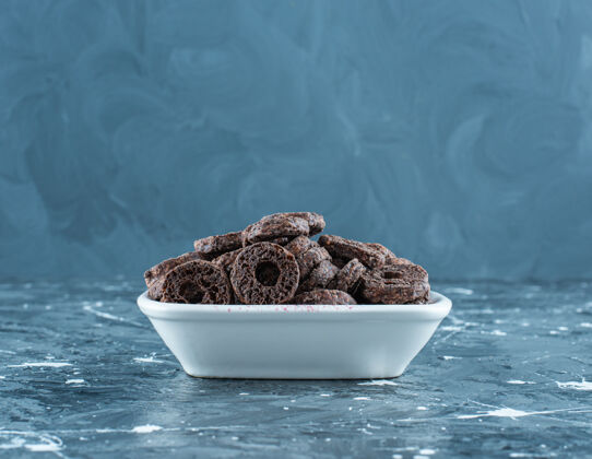 可口美味的巧克力涂层玉米圈在一个碗里 在大理石背景上糖美味牙套