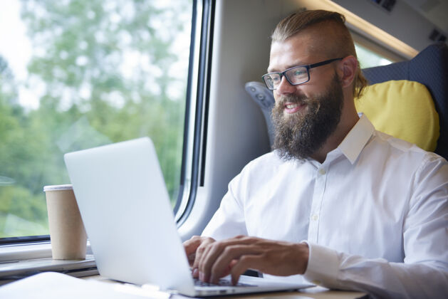 电脑有胡子的商人在旅途中工作文件旅行胡须