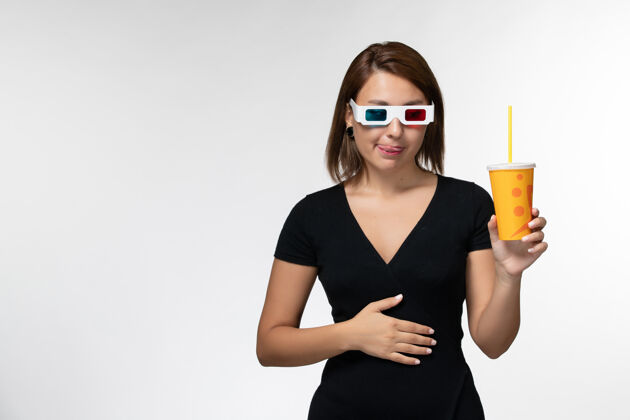 年轻女性正面图白色表面上戴着d墨镜拿着苏打水的年轻女性电影太阳镜性感