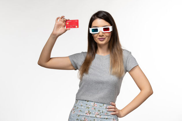 电影院正面图白色表面戴着d墨镜拿着银行卡的年轻女性女性太阳镜年轻的女性