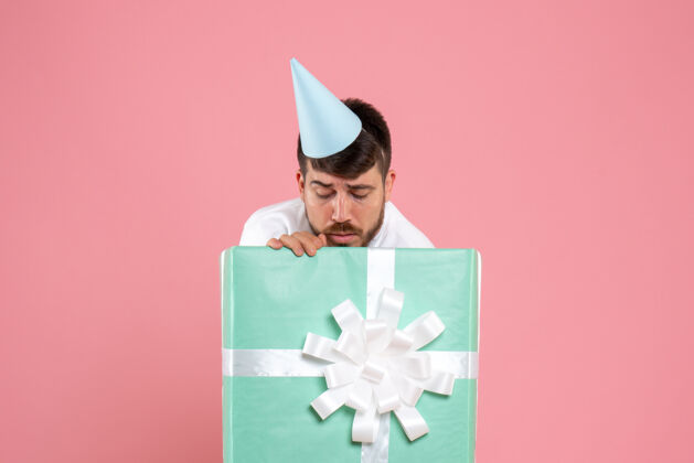 礼物正面图：年轻男性站在礼物盒内 粉色照片 人类情感圣诞睡衣派对立场帽子里面