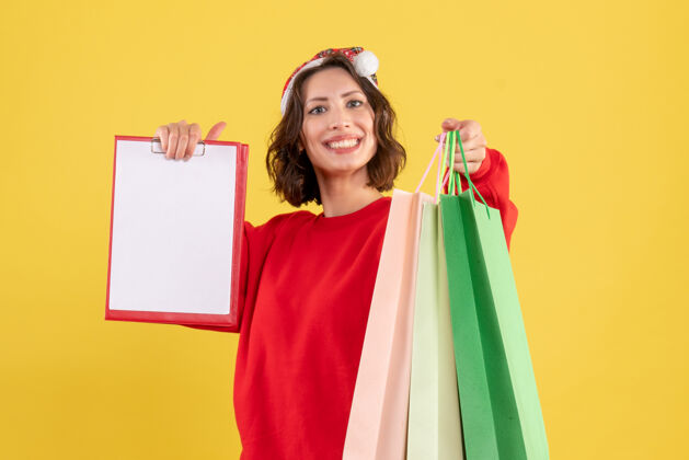 购物正面图年轻女子拿着黄色的文件和包裹盒子生活方式文件