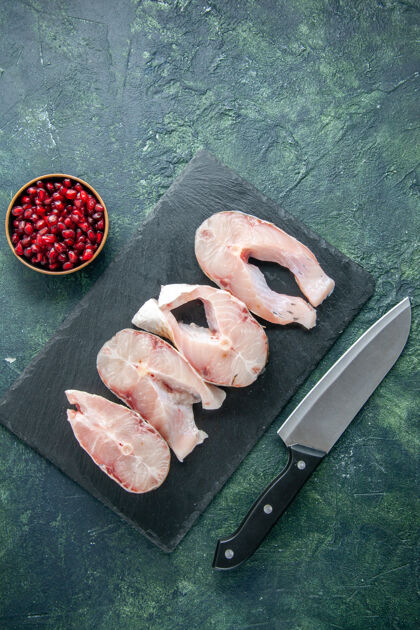 切肉刀顶视图新鲜鱼片放在一张深色的桌子上海鲜海洋肉类海餐水胡椒菜食物肉顶部刀片