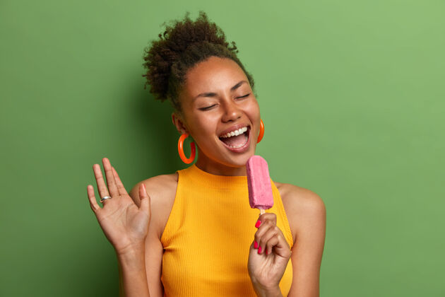 冷冻积极的非洲裔美国妇女冷草莓冰淇淋冷味道乐趣笑