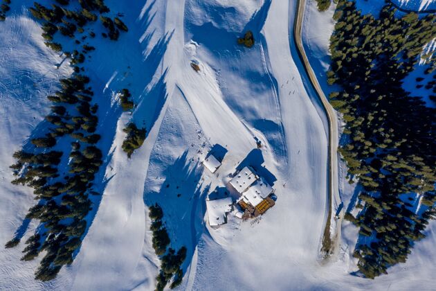自然白天 雪山上树木环绕的小房子的俯视镜头白天冰风景