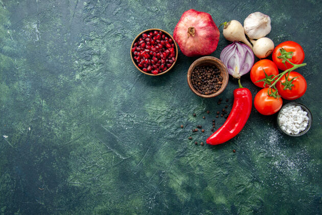 可食用水果顶视图新鲜的红色西红柿与大蒜和调味品在深蓝色背景胡椒蔬菜沙拉蔬菜大蒜胡椒