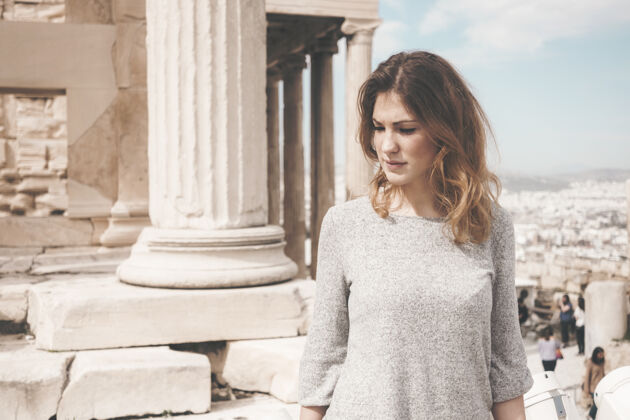 开衫白天 一个穿着灰色长袖上衣的女人站在白色水泥柱旁袖子太阳穴肖像