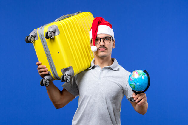 工人正面图年轻男子背着黄包上蓝墙飞机度假旅行男包气球人