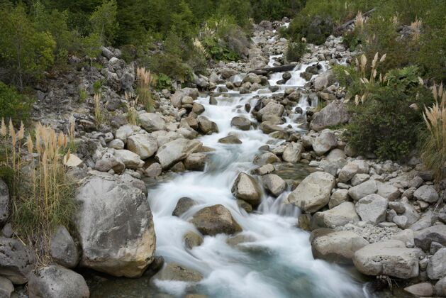 瀑一条小溪穿过森林里的岩石和树木的美丽镜头自然景春