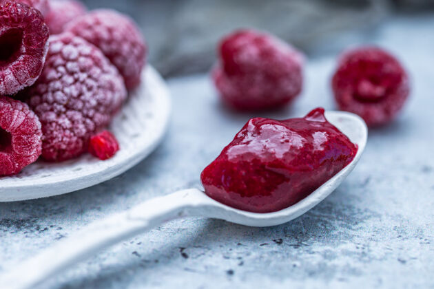 配料特写镜头的树莓果酱与冷冻树莓的背景多汁覆盆子美味