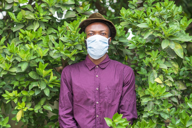 黑站在灌木丛里戴着防护面罩的年轻非洲裔美国男性人脸医疗保健