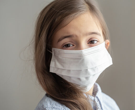 感染戴着防冠状病毒的一次性防护面具的可爱小女孩病毒疾病面具