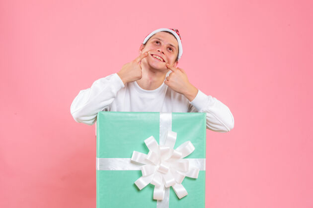 睡衣正面图：身穿白色衬衫的年轻男性 粉色背景上带着微笑的礼物礼物情感年轻男性