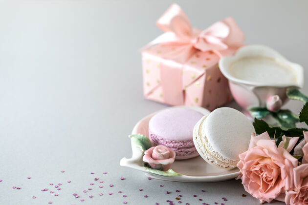 杯子一杯咖啡 做蛋糕的意大利面 一个盒子里的礼物和灰色背景上的粉红玫瑰复印空间早晨食物早餐